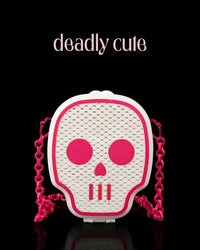 White 3D printed skull purse with hot pink facial features and a bright pink chain, blending spooky with sweet.