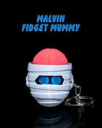 Halloween mummy fidget toy with pink brain and blue glowing eyes