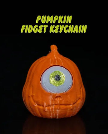 One-eyed pumpkin fidget keychain with articulated eyeball and spooky grin on black background