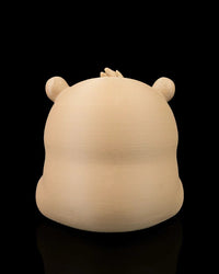 Back view of a capybara figurine showing its rounded body and small ears.
