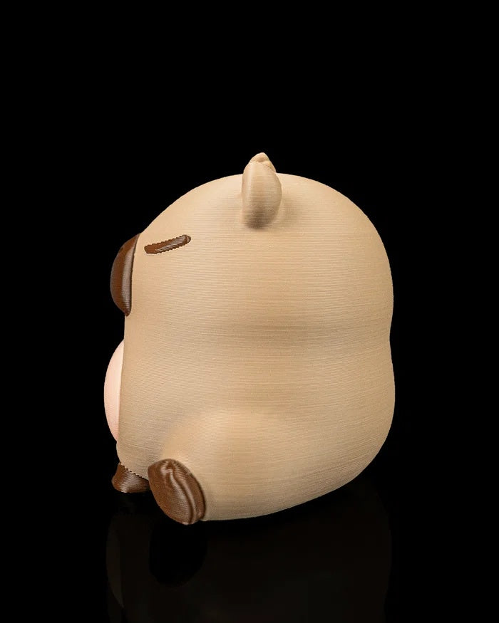 Rear three-quarter view of a capybara figurine showing its rounded body and dark foot detail.