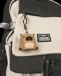 Capybara figurine hanging as a keychain from a backpack.