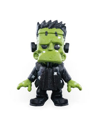 Front view of a spooky green monster figurine with black hair and a dark outfit.
