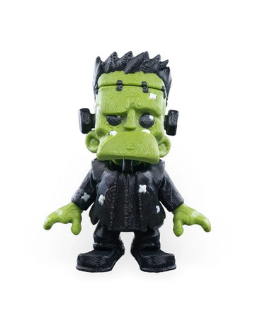 Front view of a spooky green monster figurine with black hair and a dark outfit.