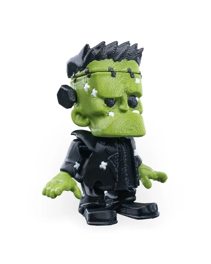 Three-quarter view of a spooky green monster figurine showing the face and side profile.