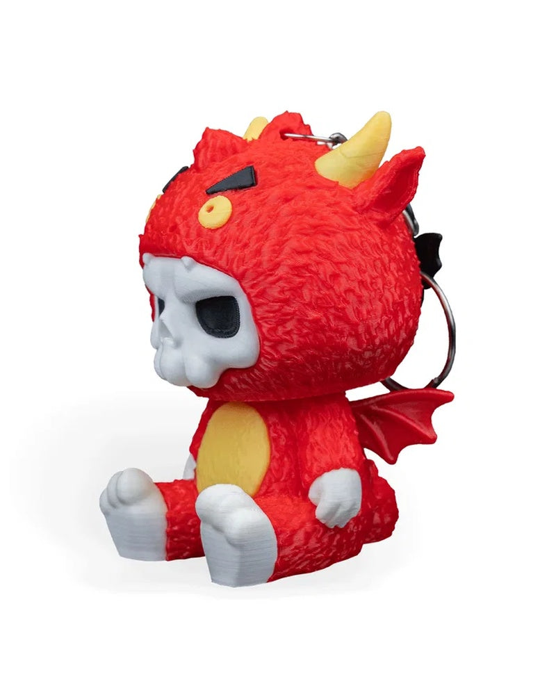 Side view of a red dragon character figurine with yellow horns, skull face detail, yellow belly, small wing, and metal ring behind it