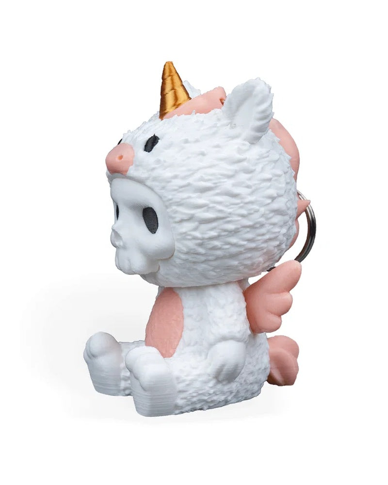 Side view of a white unicorn costume figurine with a gold horn, pink accents, and a metal ring visible behind it